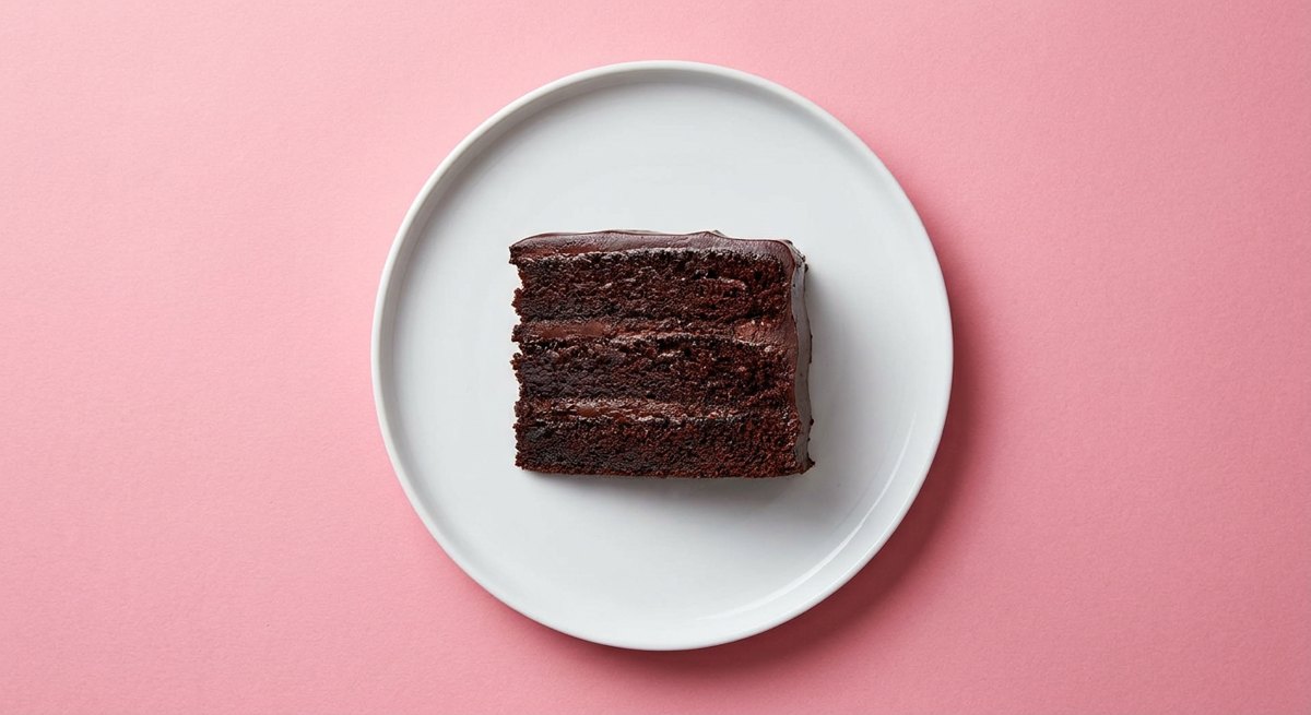 Bolo de Chocolate da Matilda em prato branco, fotografia de cima com fundo colorido