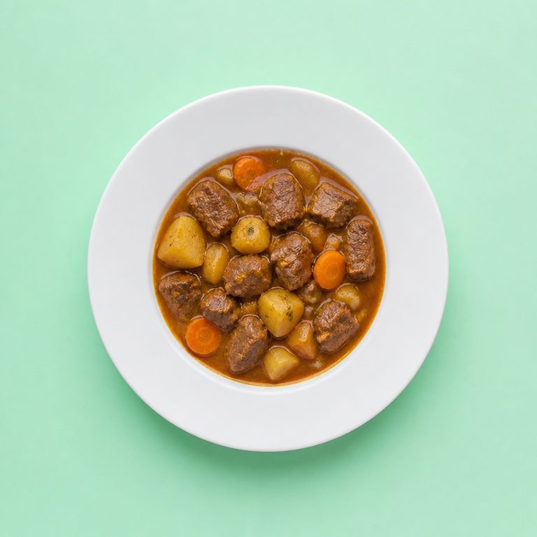 Carne de Panela em prato branco, fotografia de cima com fundo colorido