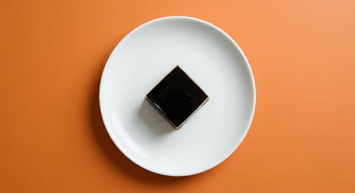 Gelatina de Café em prato branco, fotografia de cima com fundo colorido