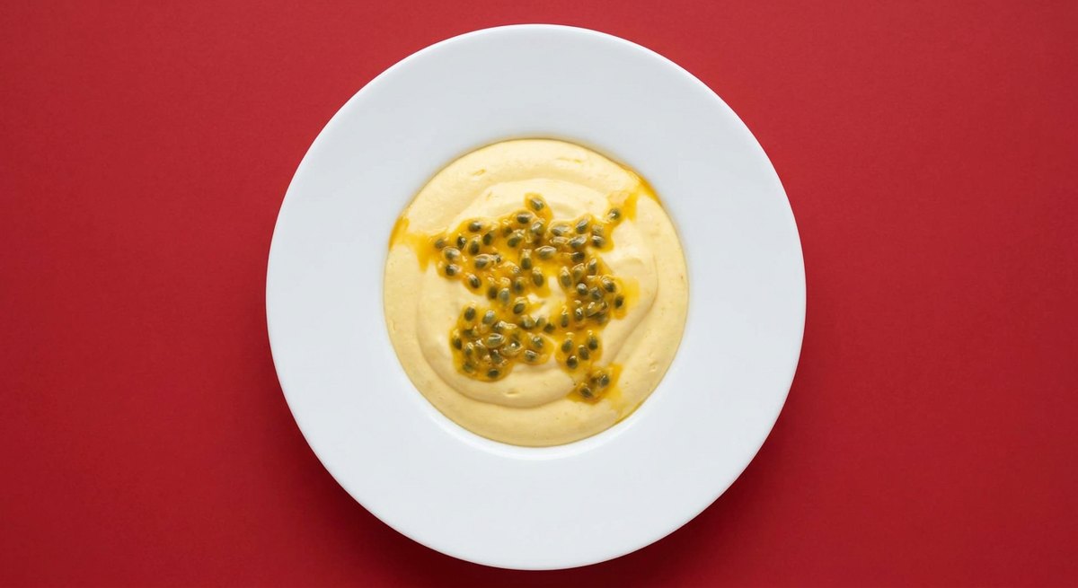 Mousse de Maracujá em prato branco, fotografia de cima com fundo colorido