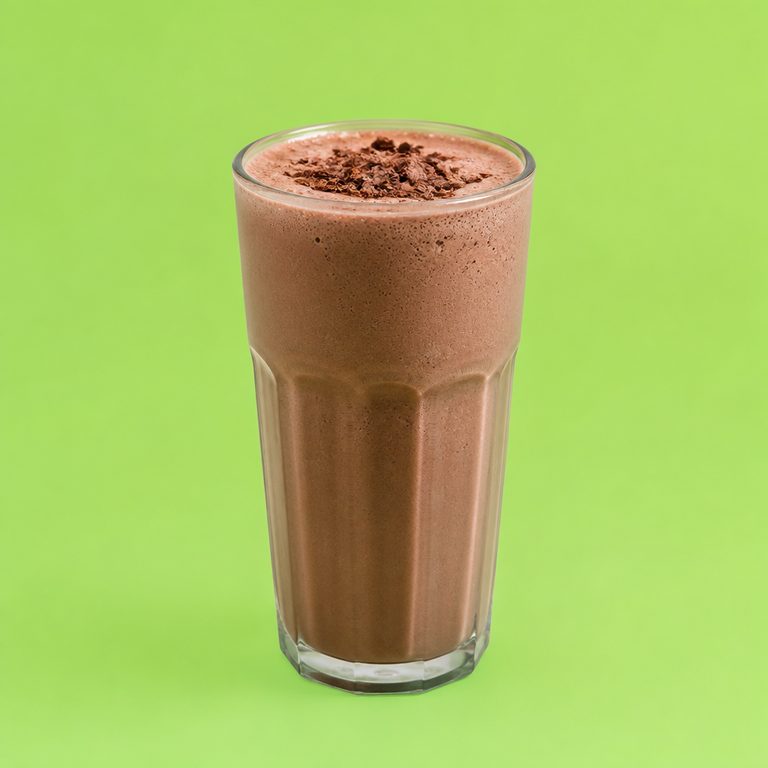 Shake de Chocolate Fitness em prato branco, fotografia de cima com fundo colorido