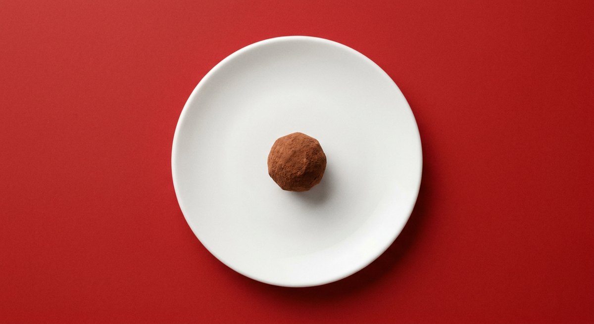 Trufa de Chocolate Fácil em prato branco, fotografia de cima com fundo colorido